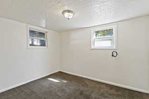 Carpeted empty room with a textured ceiling