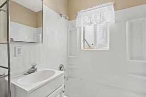 Bathroom featuring vanity and shower / bathing tub combination