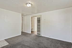 Carpeted empty room with a textured ceiling