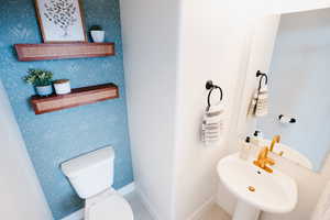 Bathroom featuring tile patterned flooring, toilet, and sink