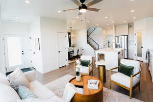 Living room featuring sink, ceiling fan with notable chandelier, and light hardwood / wood-style floors