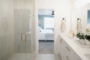 Bathroom with ceiling fan, vanity, a shower with door, and tile patterned floors