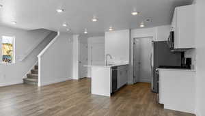 Kitchen with white cabinetry, a textured ceiling, dark wood-type flooring, and sink