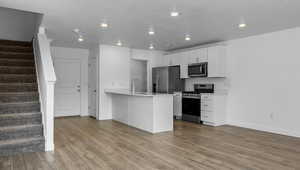 Kitchen with light wood-type flooring, sink, white cabinetry, kitchen peninsula, and stainless steel appliances