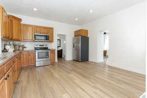 Kitchen featuring light hardwood / wood-style flooring, stainless steel appliances, and backsplash