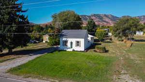 View of front of house with a mountain view and a front yard