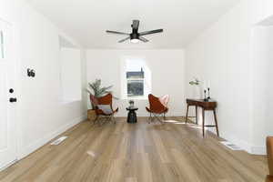 Living area with light wood-type flooring and ceiling fan