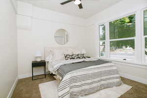 Carpeted bedroom featuring ceiling fan