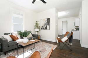 Living room with ceiling fan and dark hardwood / wood-style floors