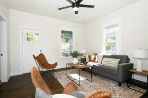 Living room with ceiling fan and dark hardwood / wood-style flooring