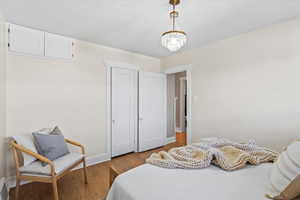 Bedroom featuring an inviting chandelier and light wood-type flooring