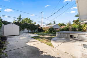 View of yard with a storage shed and a patio