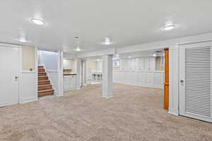 Basement with light carpet and a textured ceiling