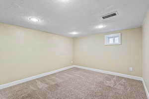 Basement featuring a textured ceiling and carpet floors