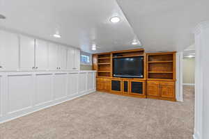 Unfurnished living room featuring light carpet and a textured ceiling