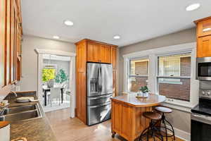 Kitchen featuring a breakfast bar, appliances with stainless steel finishes, and sink