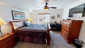 Carpeted bedroom featuring ceiling fan