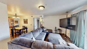 Living room with a chandelier, a textured ceiling, and dark hardwood / wood-style flooring