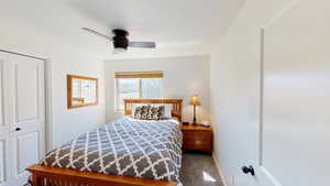 Bedroom with ceiling fan, a closet, and carpet flooring