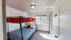 Bedroom featuring a textured ceiling and carpet flooring