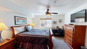 Carpeted bedroom with a textured ceiling and ceiling fan