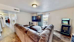 Living room with a textured ceiling and hardwood / wood-style flooring