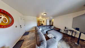 Living room with dark hardwood / wood-style floors and a notable chandelier