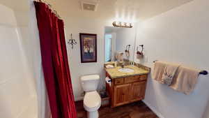 Bathroom with vanity, hardwood / wood-style floors, toilet, and a textured ceiling