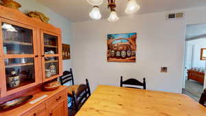 Carpeted dining space with a notable chandelier