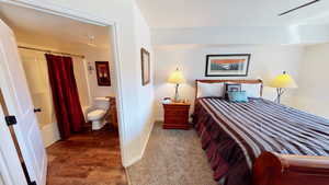 Bedroom with ensuite bathroom and dark hardwood / wood-style flooring