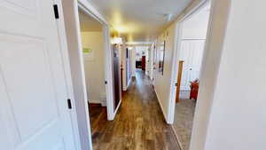 Hallway featuring a textured ceiling and dark hardwood / wood-style flooring