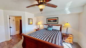 Bedroom with dark hardwood / wood-style floors and ceiling fan