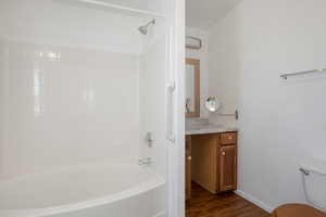 Full bathroom featuring shower / tub combination, hardwood / wood-style flooring, vanity, and toilet