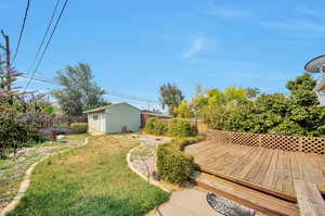 Backyard view from patio of deck and garage/workshop accessible from alleyway and backyard.