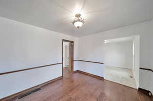 Formal dining looking into kitchen dining and master bedroom door.