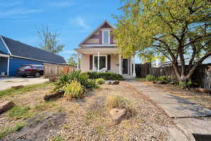 Front view of home view with xeriscape and covered porch area.