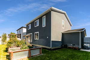 View of property exterior featuring a lawn and garden boxes