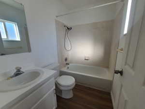 Owner's bath toilet, tub / shower combination, wood laminate floors, and vanity