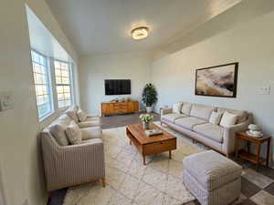 Living area featuring lofted ceiling and baseboards
