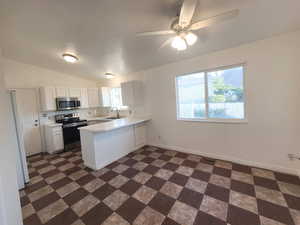 Open concept kitchen and breakfast nook with ceiling fan, white cabinets, sink, peninsula, and stainless steel appliances