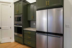 The deep green cabinetry with brushed gold hardware feel classy and sophisticated in person