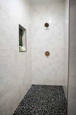 Bathroom with tilOwner's shower tiled to the ceiling with Daltile in Artic White with green niche accents, and a black stone floor pan.ed shower