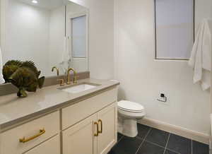 Bathroom 2 is a full bath with white cabinetry, full steel tub/shower, with tile to the ceiling.