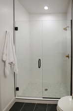 Bathroom 3 is a 3/4 bath with white cabinetry, a large shower tiled to the ceiling and euro-style glass.