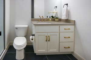 Bathroom 3 is a 3/4 bath with white cabinetry, a large shower tiled to the ceiling and euro-style glass.