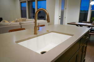 Large kitchen island with composite sink and brushed 'gold' Delta Trinsic faucet.