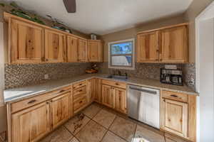 Kitchen featuring dishwasher, tasteful backsplash, and sink