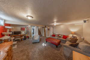 Carpeted living room featuring a textured ceiling