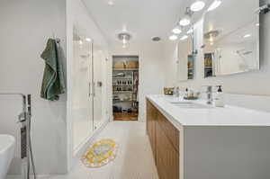 Bathroom with tile patterned flooring, vanity, and an enclosed shower