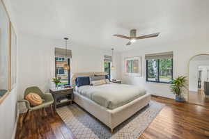 Bedroom with multiple windows, ceiling fan, and hardwood / wood-style flooring